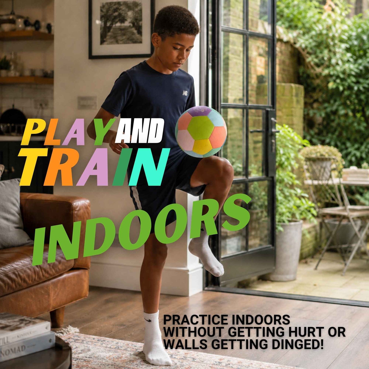 A boy wearing a navy blue Nike t-shirt and shorts kicks a colorful House Ball - EE indoors near a glass patio door, with large text overlays reading 'PLAY AND TRAIN INDOORS' and a smaller tagline about practicing indoors without getting hurt or walls getting dinged.