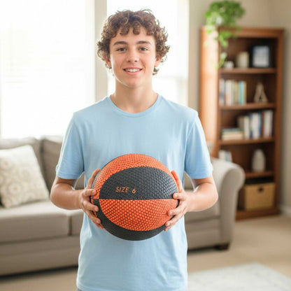 Person holding a size 6 HouseHoops Basketball in a living room setting