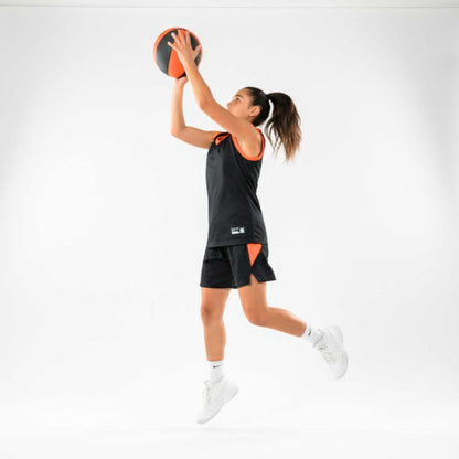 Person in athletic wear holding a HouseHoops basketball against a white background